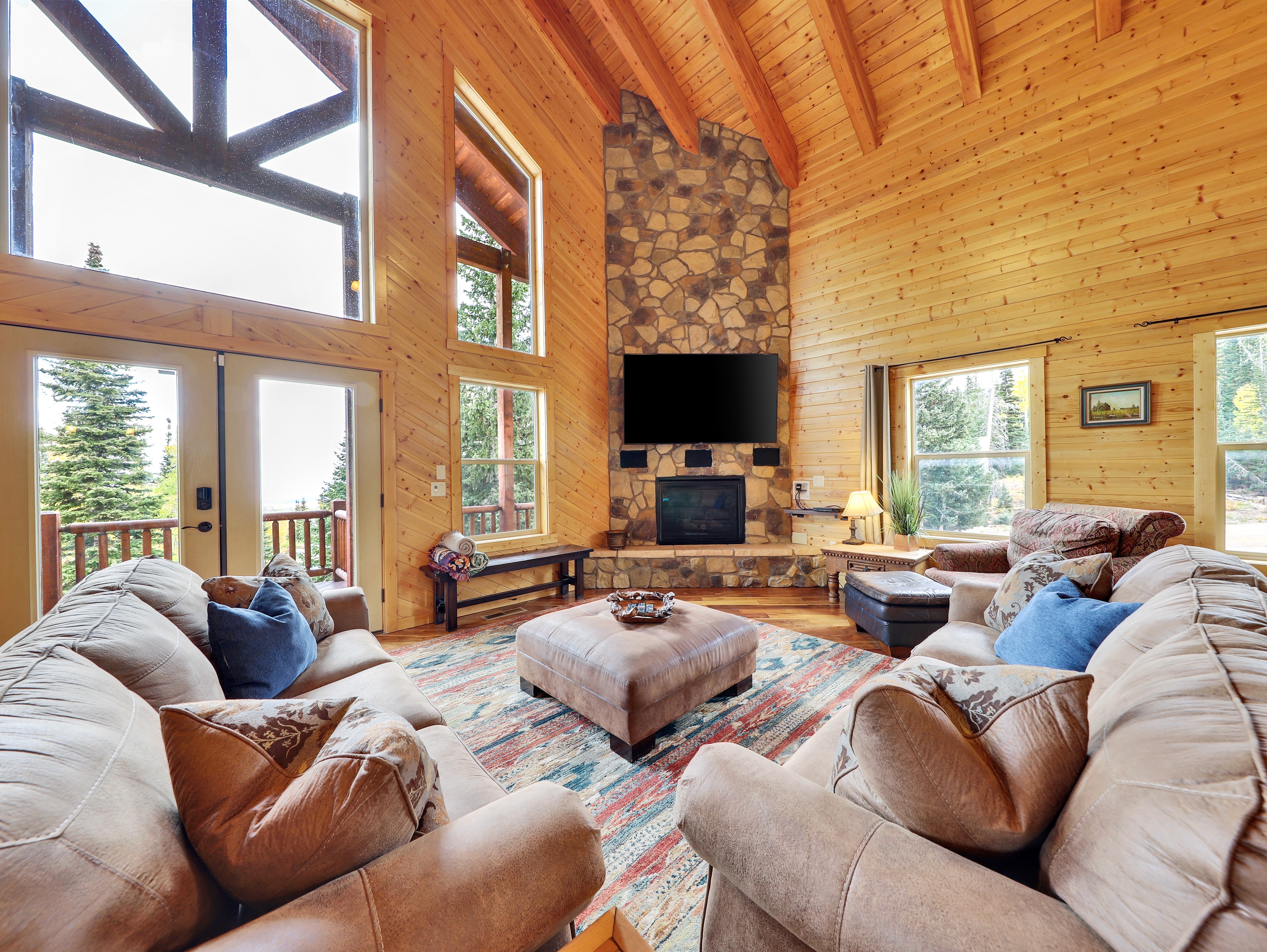 Spacious log cabin living room with stone fireplace